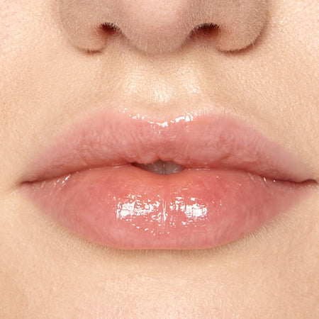 Lip Fudge plumping lip conditioner. Round glass tub with white screw top lid showing Clear's neutral shade through the container.